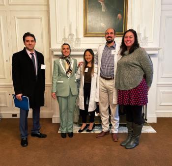 five radiologists standing in front of a white fireplace